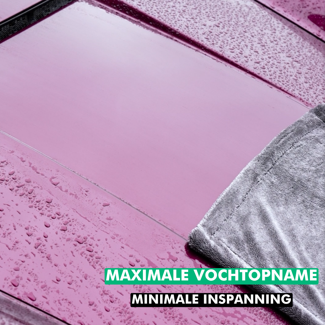 Grijze Extreme Drying Towel microvezel droogdoek die water van een roze oppervlak opneemt, 1400GSM XXL formaat.